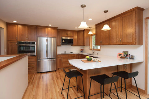 Luxury kitchen featuring polished quartz countertops complemented by classic cherry wood cabinetry.